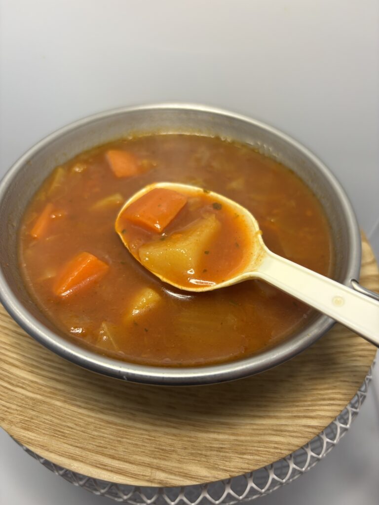 無印良品 1/3日分の野菜を使った トマトスープ 加熱 中身を出したところ スプーンですくった図